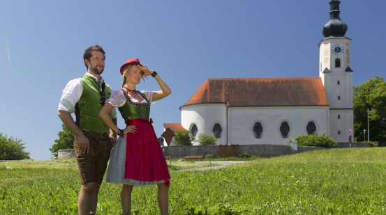 Frau und Mann in Tracht vor der Wallfahrtskirche in Bad Kötzting