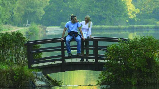 Frau und Mann auf einer Brücke über den See